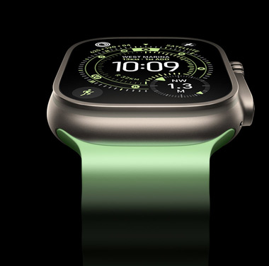 A close-up of a Natural Titanium Apple Watch Ultra 3 on a black background. The display shows the time and other dynamic info.