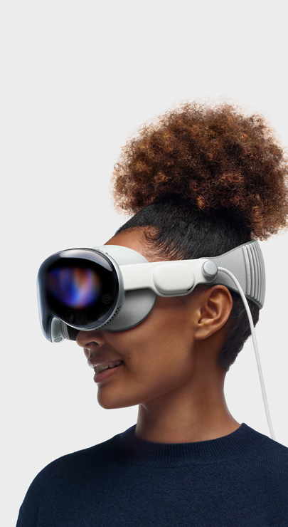 Eine Person lächelt, während sie sich mit der die Apple Vision Pro Inhalte ansieht