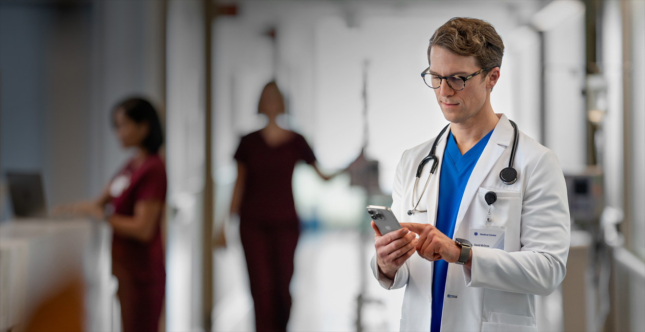 Un medico che guarda il suo iPhone in un ospedale.