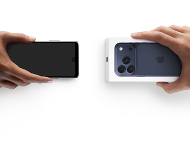 Twee handen wisselen telefoons uit, de linkerhand heeft een Android-telefoon zonder doos vast, de rechterhand heeft een nieuwe iPhone 17 Pro in de verpakking vast