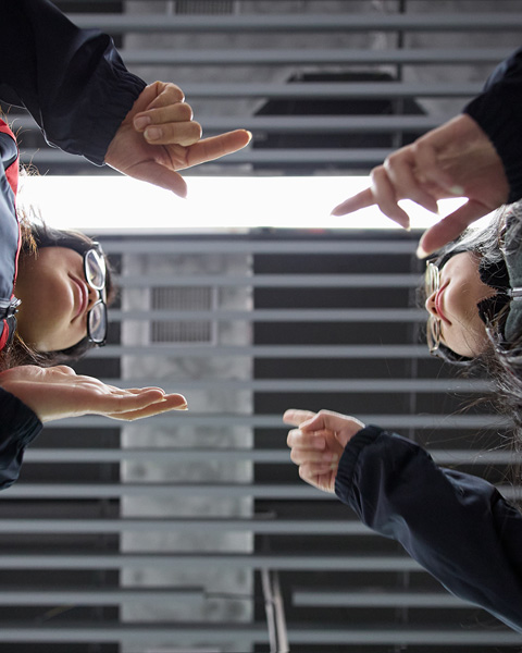 Ground shot of two employees communicate in sign language with each other