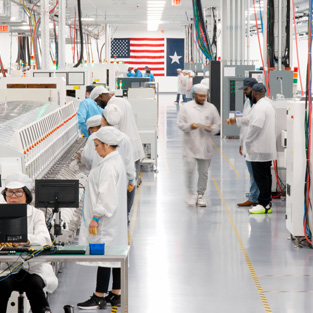 Employees in full-coverage work suits work in an AI server assembly facility